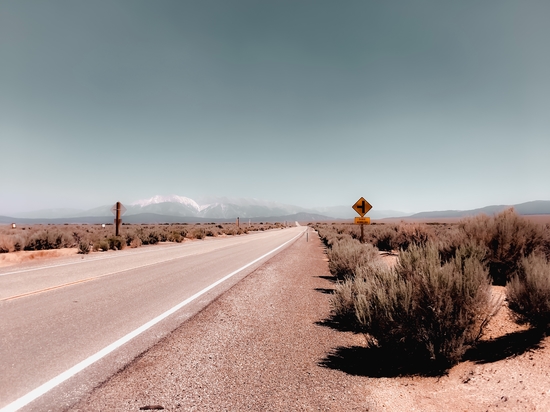 Road in the desert with blue sky and mountain view in California USA by Timmy333