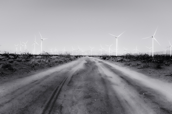 road in the desert with wind turbine in black and white by Timmy333